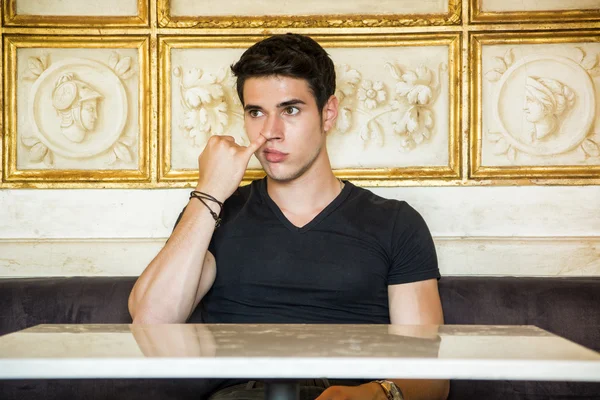 Young Man Sitting at Table Picking Nose — Stock Photo, Image