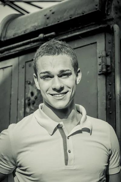 Handsome young man leaning against old train — Stok fotoğraf