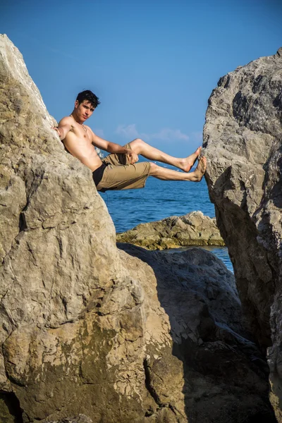 Young Man Spanning Gap Between Coastal Boulders — Stock Photo, Image