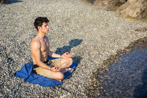 Junger Mann meditiert oder macht Yoga-Übungen auf dem Meer — Stockfoto