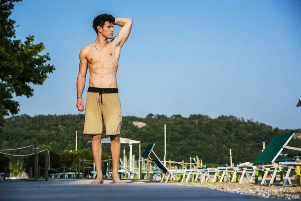 Camisa atlética joven de pie en la playa — Foto de Stock