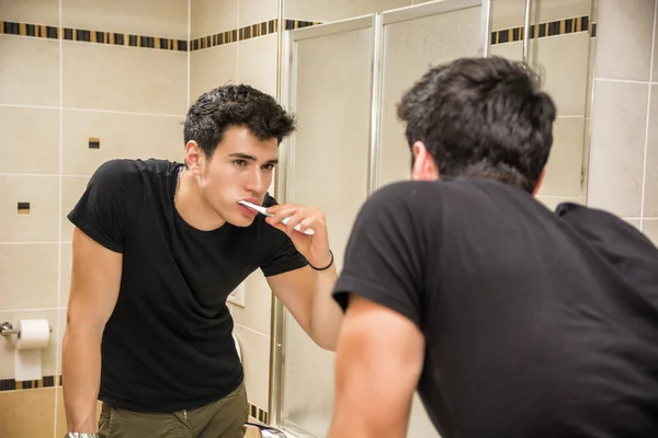 Headshot van aantrekkelijke jonge man tanden poetsen — Stockfoto