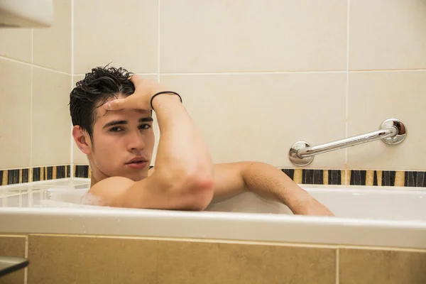 Handsome young man in bathtub at home having bath — Stock Photo, Image