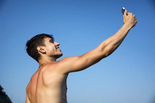 Shirtless Young Man Taking Selfie Photos at the Beach