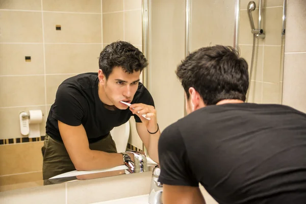 Headshot of attractive young man brushing teeth — Stock Photo, Image