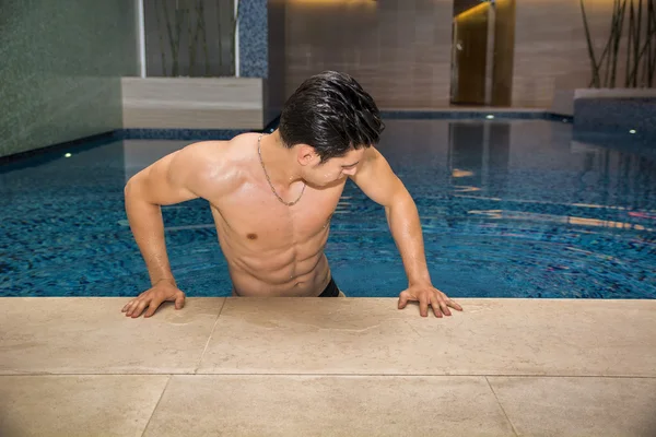 Homem jovem relaxante na piscina — Fotografia de Stock