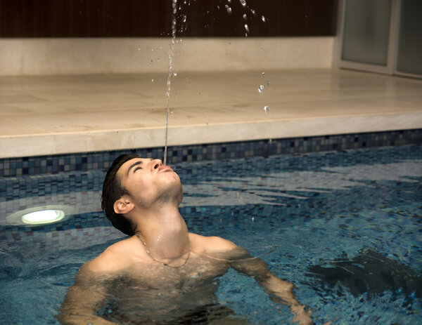 Young Man Playing in Swimming Pool, Spitting Water