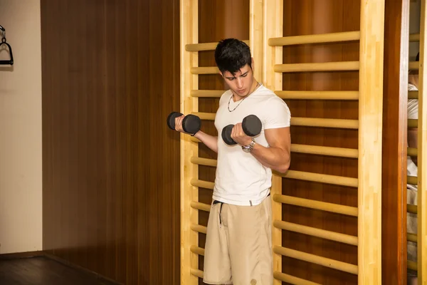 Séduisante jeune homme travailler avec haltères au gymnase — Photo