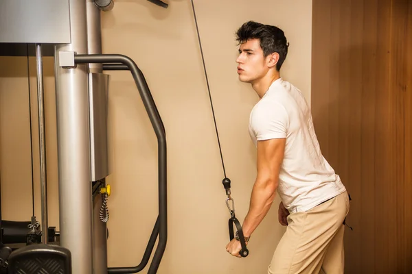 Bello giovane uomo che lavora fuori su attrezzature da palestra — Foto Stock