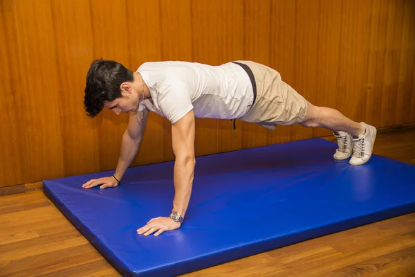 Schöner junger Mann trainiert im Fitnessstudio — Stockfoto