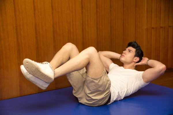 Handsome young man working out in gym — Stock Photo, Image