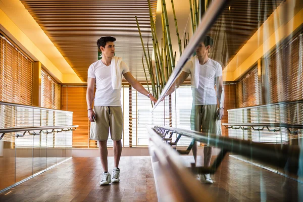 Young Man Standing in Hallway Holding Hand Rail — Stock Photo, Image