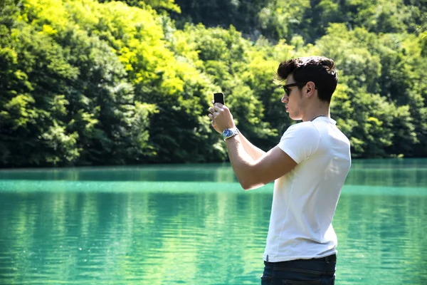 Beau jeune homme sur un lac dans une journée ensoleillée et paisible — Photo