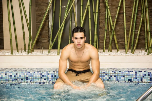 Hombre joven relajante en el jacuzzi del spa — Foto de Stock