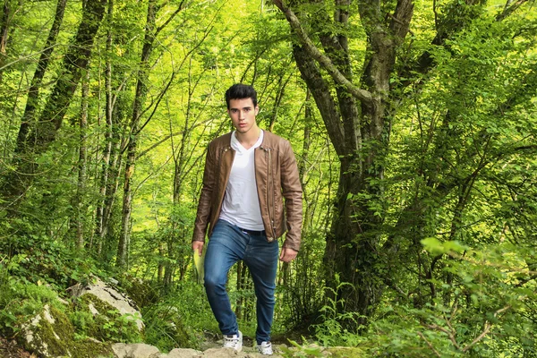 Jovem caminhadas em exuberante paisagem de montanha verde — Fotografia de Stock