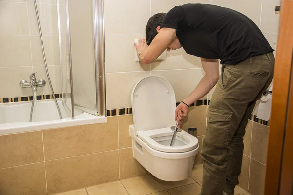 Jeune homme nettoyage de la salle de bain WC, latrines essuyage — Photo