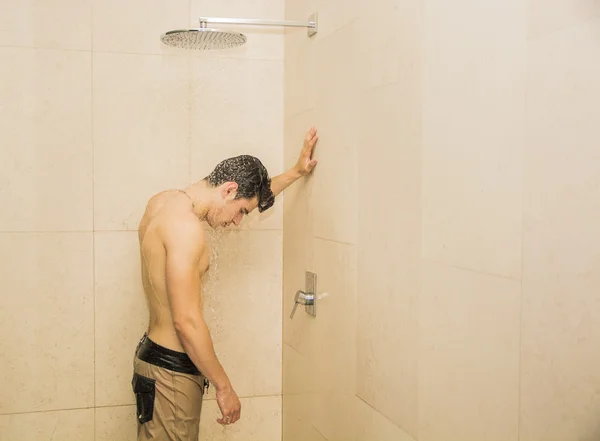 Привлекательный молодой мускулистый человек принимает душ — стоковое фото