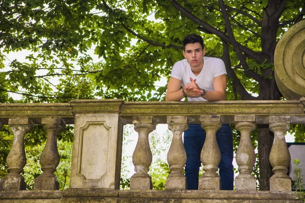 Handsome young man standing on a balcony or bridge — ストック写真