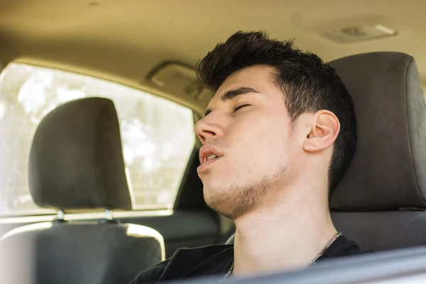 Jongeman die achter het stuur slaapt en zijn auto bestuurt — Stockfoto