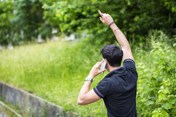 Young man on side of a road, calling and waiting for taxi — 图库照片