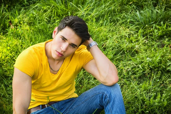 Fit handsome young man relaxing lying on lawn grass — Stock Photo, Image