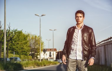 Şehir sokak yürüyen siyah deri ceketli genç adam