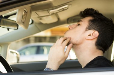 Man Looking at his Pimple Using Mirror of a Car