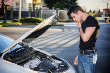 Bir araba motoru tamir etmeye çalıştığını yakışıklı genç