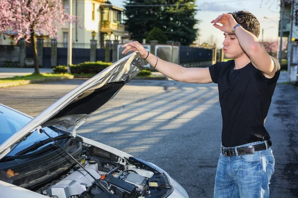 車のエンジンを修理しようとすると、ハンサムな若い男 — ストック写真