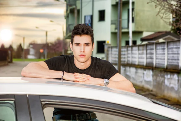 Young man sitting on his cars door, resting on the roof — 图库照片