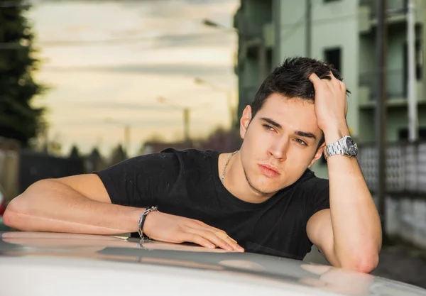 Young man sitting on his cars door, resting on the roof — Stok fotoğraf