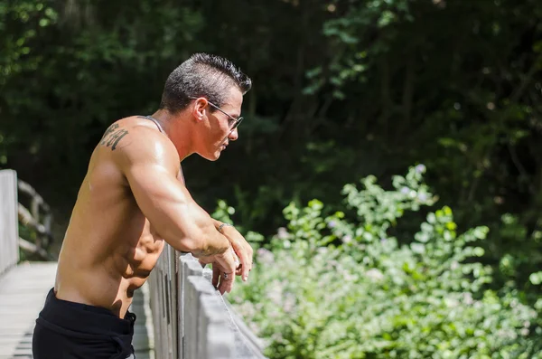 Séduisante jeune bodybuilder en plein air, se penchant — Photo