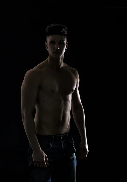 Young hip man in jeans, shirtless, isolated on black — Stock Photo, Image