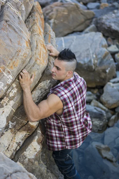 Knappe Man klimmen van een rots in de rivier — Stockfoto