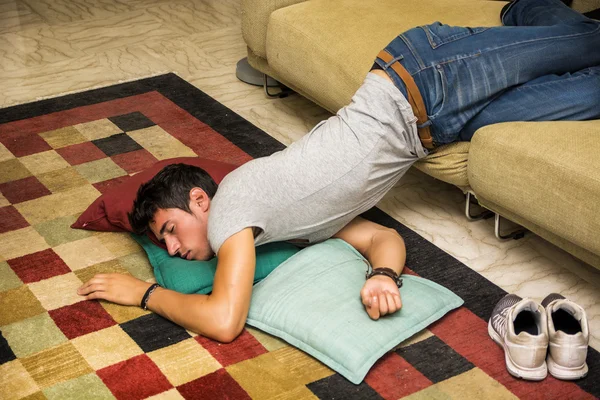 Пьяный мужчина отдыхает на диване с головой на полу — стоковое фото