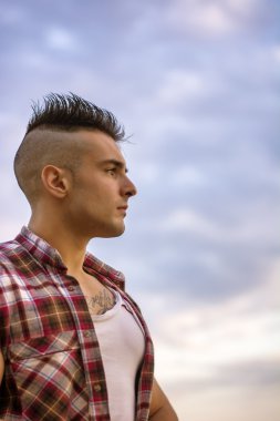 Yakışıklı atletik adam uzakta gökyüzü karşı arıyorsunuz