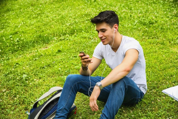 Joven escuchando música en el parque —  Fotos de Stock