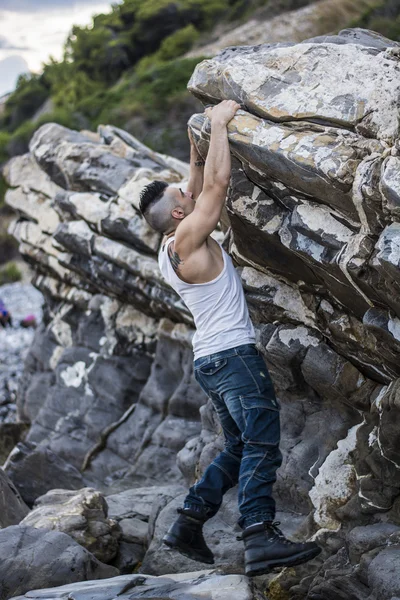 Schöner Mann, ein Kletterfelsen am Fluss — Stockfoto