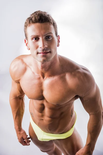 Muscular jovem fisiculturista em pose descontraída, sorrindo — Fotografia de Stock