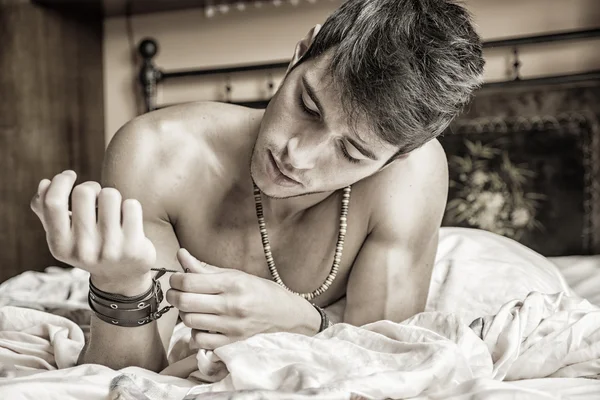 Shirtless sexy modelo masculino deitado sozinho em sua cama — Fotografia de Stock