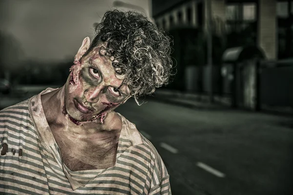 Um zumbi masculino em pé na rua no dia das Bruxas da cidade vazia — Fotografia de Stock