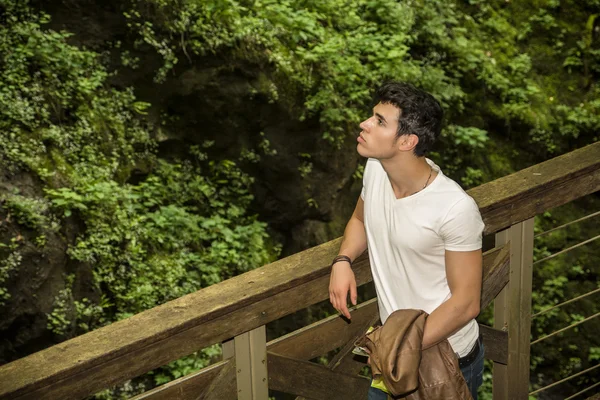 Gut aussehender junger Mann stützte sich gegen Pathway Schiene — Stockfoto