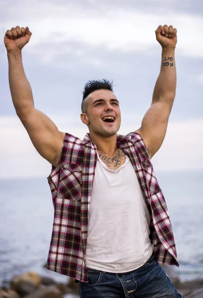 Muscular young man with hands up for victory — Stock Photo, Image