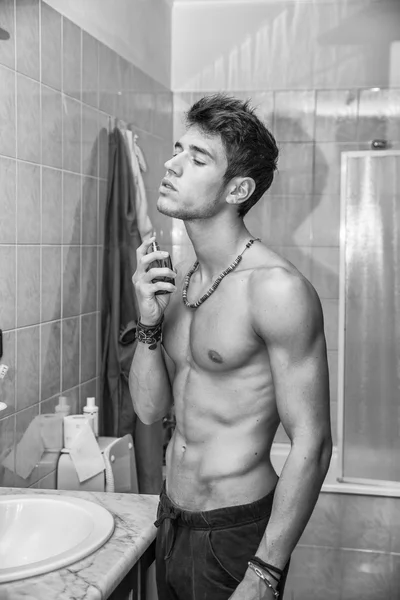 Bel giovane uomo in bagno, spruzzo di Colonia o profumo — Foto Stock