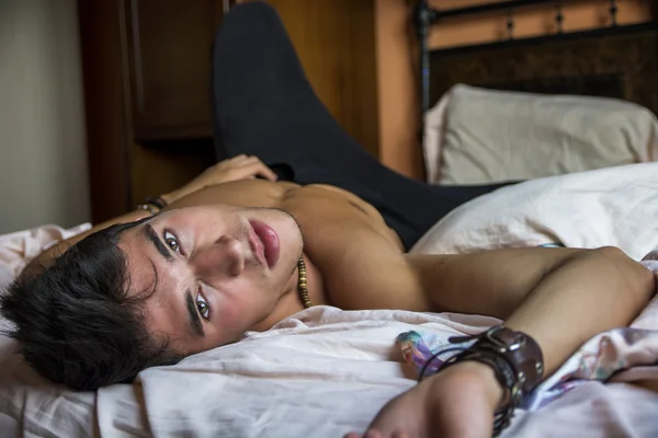 彼のベッドの上に一人で横たわっている愚かなセクシー男性モデル — ストック写真