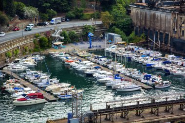 Yachts in Small Marina by Road in Industrial Area