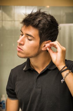 Young Man Cleaning Ears with Cotton Swab