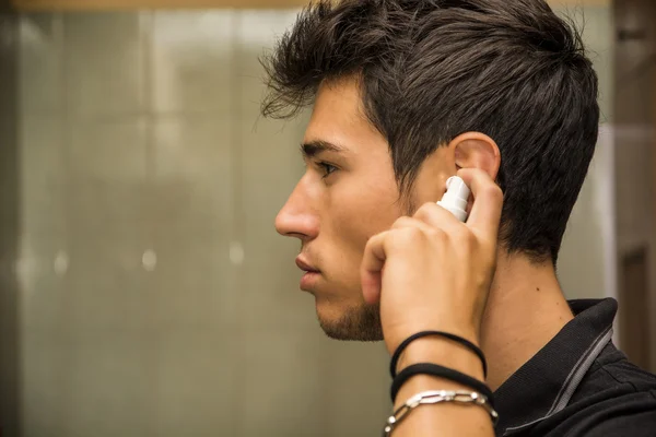 Young Man Spraying Ear Spray into Ears — Zdjęcie stockowe