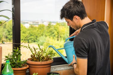 Daire balkon sulama bitkilerin genç adam