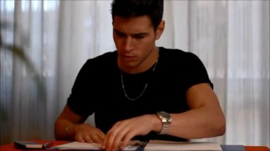 Genç adam çalışma veya masada eğitim sırasında esneme